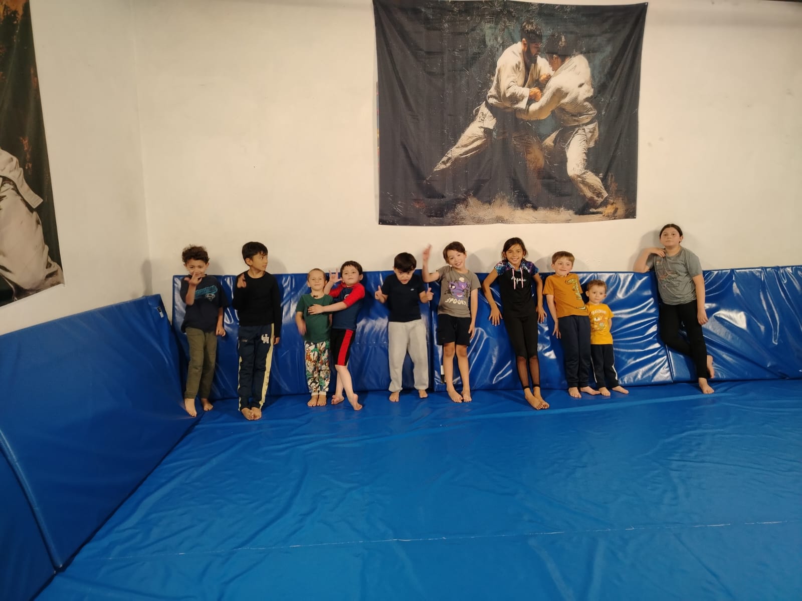 Equipo de alumnos del Club de Judo ERA junto al mural del dojo en San Ángel Inn, CDMX