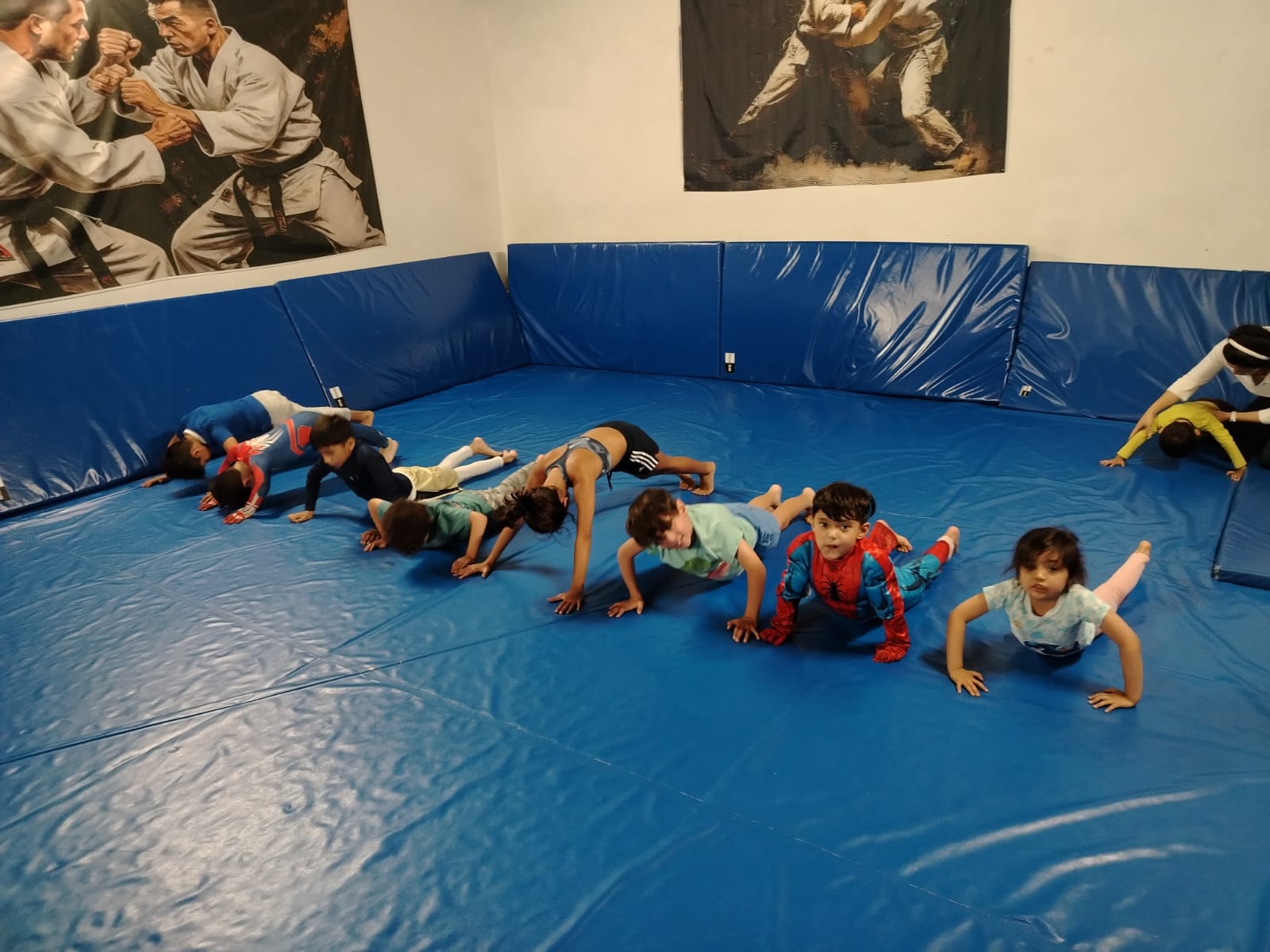 Niños haciendo lagartijas durante el calentamiento de una clase de judo infantil en CDMX